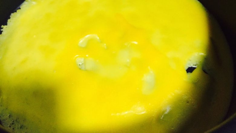 芒果班戟,慢慢晃动小奶锅，使蛋液均匀平铺锅底