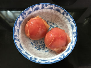 番茄鸡肉丸,2个番茄表面用刀划个十字，放入开水中烫1分钟后捞出备用。