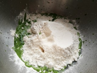 造型馒头——苦瓜豆沙包,把菠菜汁倒入盆中，先加入酵母搅拌溶解，再加入面粉，搅拌成面絮状。
