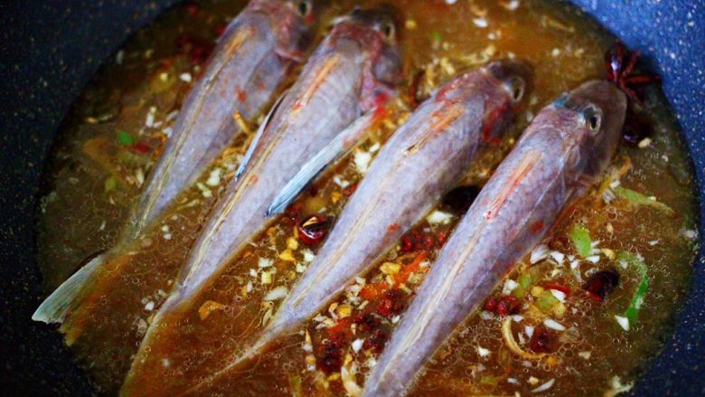 酱焖红蟹鱼青菜,把洗净的红蟹鱼放到锅中。