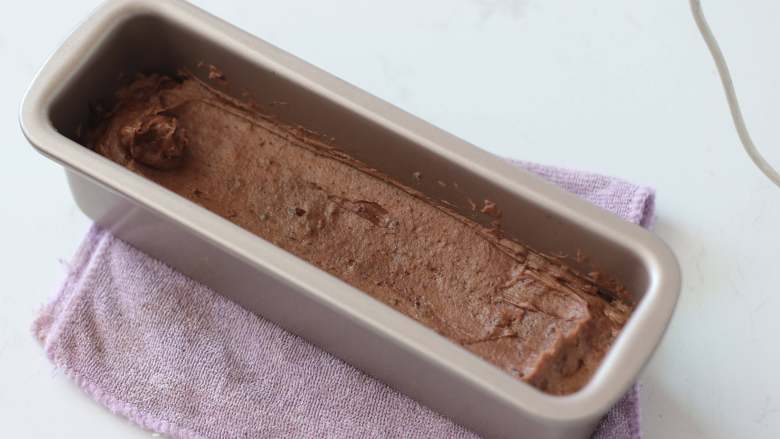 咖啡巧克力核桃脆皮磅蛋糕,剩余面糊全部挤入模具后，用刮刀将面糊整理为中间低两边高的凹形。