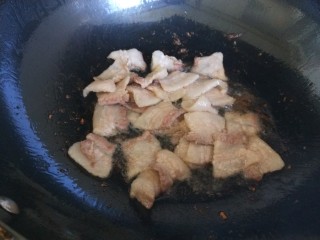 五花肉炒蒜苔,锅中倒入油，倒入五花肉片炒出油。