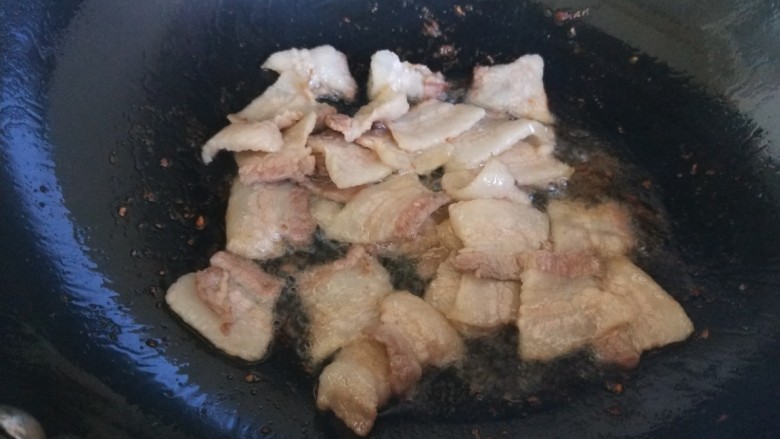 五花肉炒蒜苔,锅中倒入油，倒入五花肉片炒出油。