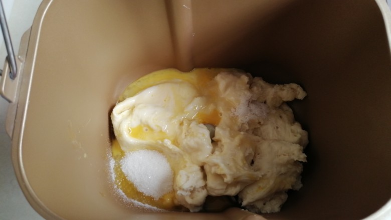 中种炼奶排包,将中种面团撕成小块放入面包桶，加入26克蛋液，50克炼奶，18克糖，3克盐（糖和盐对角放）。