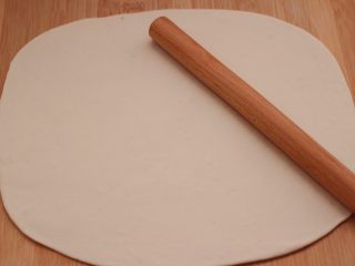 香葱火腿花卷,用擀面杖擀成一块尽量大的长方形薄面片。
