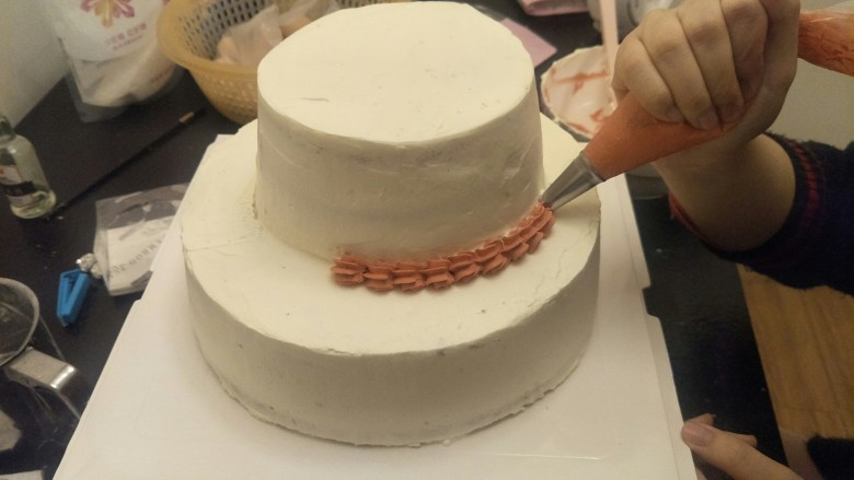 贺寿双层蛋糕(10＋6寸),剩下的奶油调一点红色裱花一圈