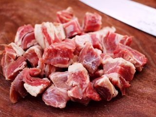 红烧牛肉炖大蒜,把牛肉洗净后，用刀切成小块。
