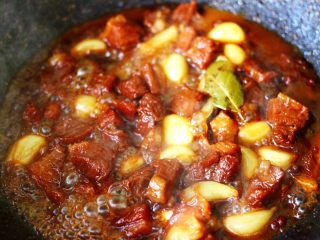红烧牛肉炖大蒜,小火继续炖煮至牛肉和大蒜变得软糯的时候。