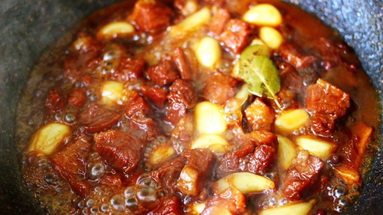 红烧牛肉炖大蒜,小火继续炖煮至牛肉和大蒜变得软糯的时候。