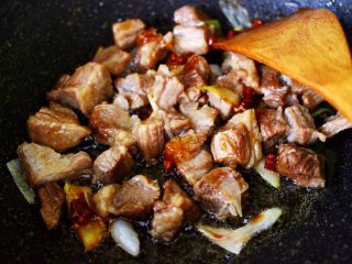 红烧牛肉炖大蒜,这个时候放入焯水的牛肉块，大火翻炒片刻。