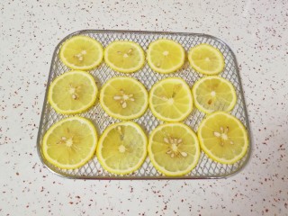 缤纷水果干,柠檬表皮用盐搓洗干净，切成薄片，摆在烤网上。