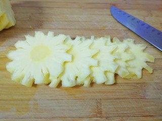缤纷水果干,菠萝去皮以后切成薄片，放入碗里用淡盐水浸泡10分钟左右。