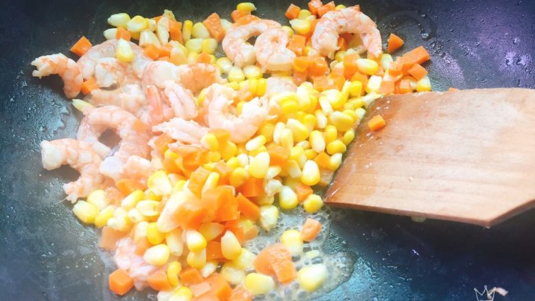 胡萝卜玉米炒虾仁,虾仁翻炒均匀，倒玉米和胡萝卜先炒一会。这样炒出的玉米口感很香甜。虾也Q弹。