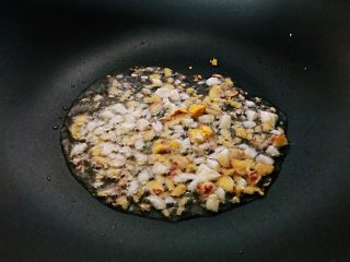 枸杞苗炒粉条,锅中倒有一点葵花籽油，加入一部分大蒜末和生姜末炒出香味。