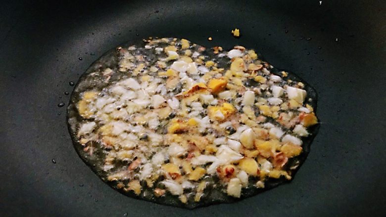 枸杞苗炒粉条,锅中倒有一点葵花籽油，加入一部分大蒜末和生姜末炒出香味。
