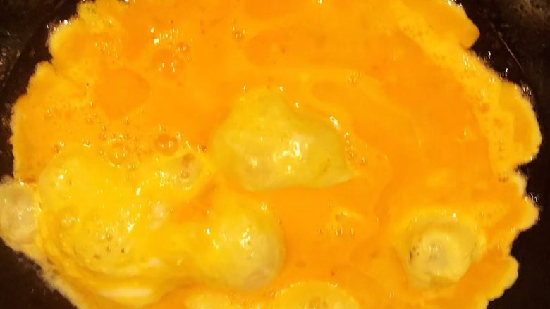 西红柿鸡蛋盖饭,锅中倒入底油加热倒入打散的蛋液