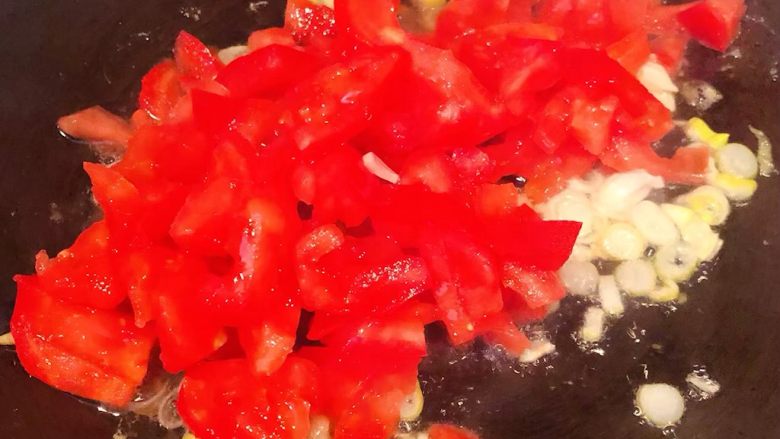 西红柿鸡蛋盖饭,锅中另起油加热放入葱花爆香再放入西红柿大火翻炒