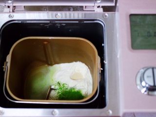 双色西葫芦韭菜生煎包,东菱面包机里，加入称重的面粉和菠菜粉，再加入1.5克酵母和85克清水，启动面包机的和面模式开始和面。