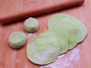 双色西葫芦韭菜生煎包,摁扁后用擀面杖擀成圆形薄面皮。
