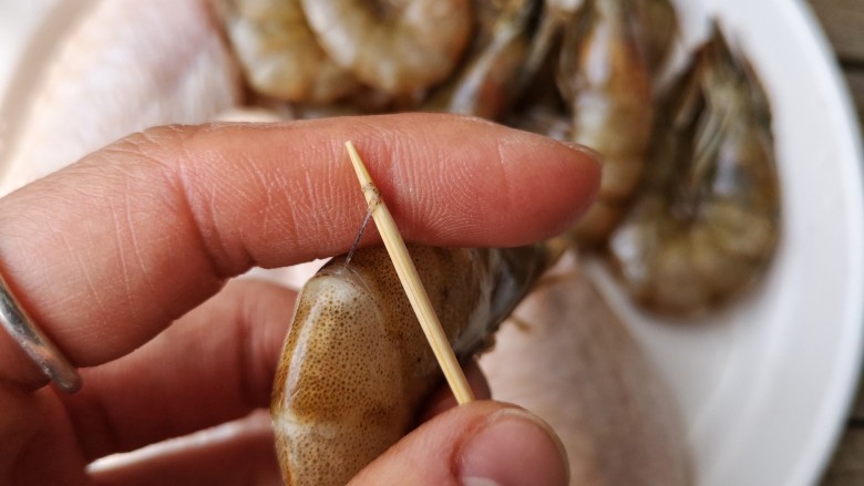 麻辣香锅——麻辣界的扛把子,用牙签从虾的第二节和第三节连接处插入挑出虾线。