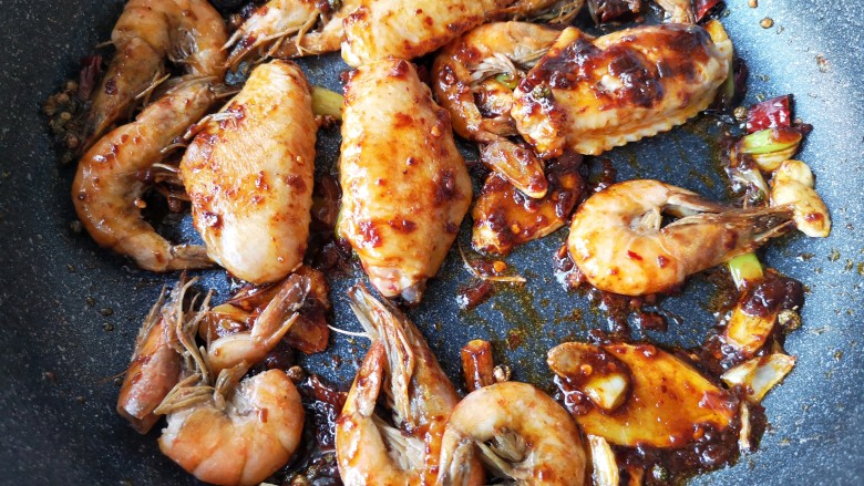 麻辣香锅——麻辣界的扛把子,下入煎好的鸡翅和虾，翻炒均匀。