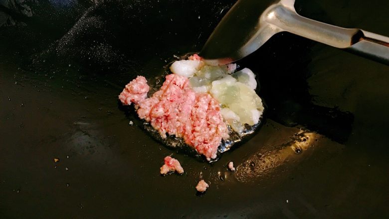 烤鱿鱼包饭,锅水热少许油，放入肉末和鱿鱼籽，翻炒。