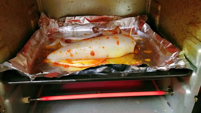 烤鱿鱼包饭,烤箱预热200度，上下火，中层，烤至鱿鱼熟了即可，约10分钟。注意观察。
