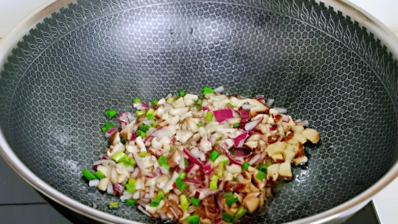 彩椒香菇辣酱,起油锅，加入洋葱煸炒，再加入香菇煸炒。