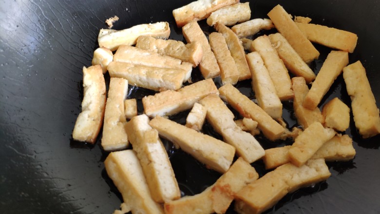 蒜薹炒豆腐,把豆腐条都煎成这样两面金黄。煎黄的豆腐条炒起来就不会碎了。