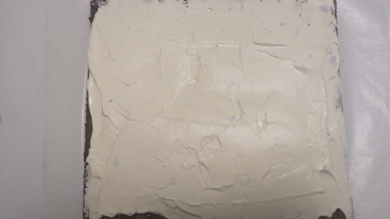 小熊熊蛋糕卷,蛋糕片上面盖一张油纸，在倒扣过来，蛋糕尾部切一斜边。奶油加糖打8分发，辅到蛋糕片上，尾部涂薄一点。