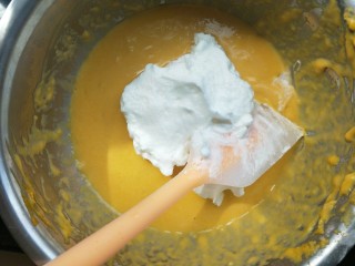 南瓜蒸蛋糕,挖三分之一蛋白到蛋黄糊里翻拌均匀。之后再挖三分一。