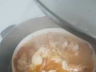 家烧虾,打开蒸锅锅盖，冒着蒸汽呢，小心烫，把蒜末均匀潵在虾上，然后淋上热油，把你刚才锅里煮的玉米油都淋上去。