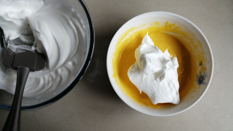 肉松元宝蛋糕,取1/3打发好的蛋白霜到蛋黄糊里，从底部向上翻拌并切拌均匀
