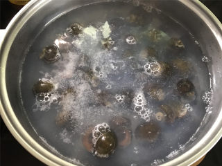 香辣田螺塞肉,锅中倒入适量清水煮开，把田螺放入锅中煮5分钟后捞出。