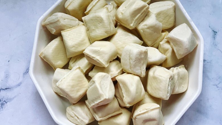 锅包豆腐,首先准备好需要的食材，拆开包装好的豆腐，用清水冲洗一遍，然后沥干水备用。