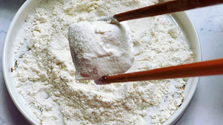 锅包豆腐,用筷子夹豆腐到面粉里滚上一圈，豆腐的每个面沾上面粉就行。