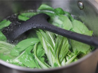 青菜炒火腿,烧一锅开水，水中加少量食盐和食油，下入小油菜汆烫10秒。然后迅速捞出来过两遍冷水。
