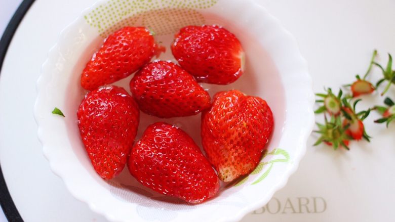 牛奶草莓奶昔,碗里加入适量的清水，把去蒂的草莓放入。