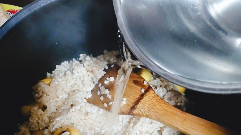 排骨板栗饭,从炒锅里将米饭盛至电饭锅，加入清水，清水的量是平时煮白米饭🍚时的量再加半小碗的量，因为板栗，肉也会吸收些水分。