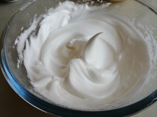 波浪纹双色戚风蛋糕,蛋清分三次加入糖，用电动打蛋器打至偏干性发泡的蛋白霜。将打发好的蛋白霜同样分成两份