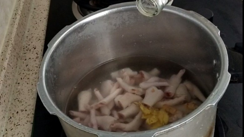 香卤鸡爪,把洗净的鸡爪放入锅中，加入清水，放入拍碎的姜，两勺料酒
