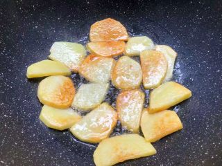 香辣土豆,待一面煎至焦黄，再翻另一面继续煎制，两面煎好盛出来待用。