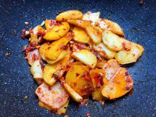 香辣土豆,再把煎好的土豆片放入快速翻炒均匀，加入少许盐、少许鸡精、少许白糖翻炒至入味。