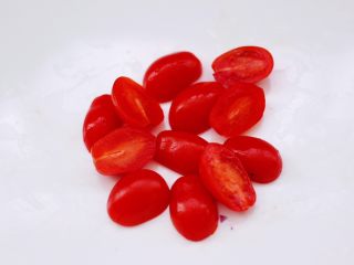 蒜香沙拉时蔬水果,水果番茄用刀一切两半。