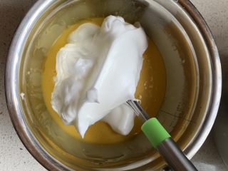 古早蛋糕,取三分之一蛋白霜到蛋黄糊中，翻拌均匀