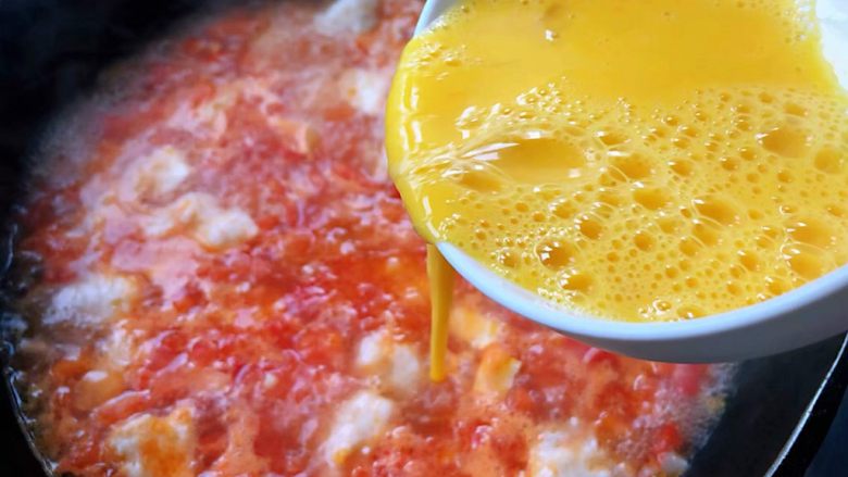 虾滑番茄豆腐蛋花羹,鸡蛋打散搅拌成蛋液均匀的淋入沸腾的汤汁中