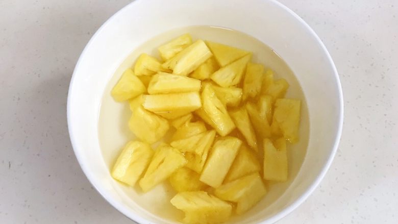 菠萝咕噜肉,往清水中加入1~2克盐，把切好的菠萝块浸泡20分钟。