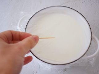 红豆双皮奶,盖上保鲜膜，用牙签在保鲜膜表面扎几个小孔