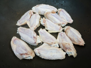 麻辣鸡翅,取一平底锅，锅中不放一滴油，将鸡翅正面朝下铺在锅底