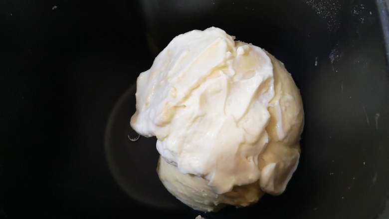 绵软美味的淡奶油花包,面团光滑时，加入淡奶油，继续揉面。